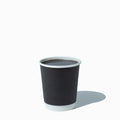 Close-up of 8 oz black paper ice cream cups stacked and ready to serve