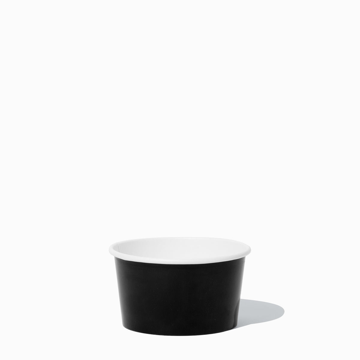 Close-up of 8 oz black paper to-go containers stacked and ready to serve