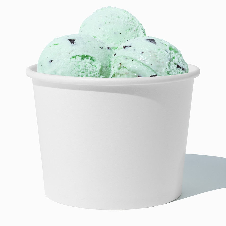 Close-up of 16 oz white paper ice cream cups stacked and ready to serve
