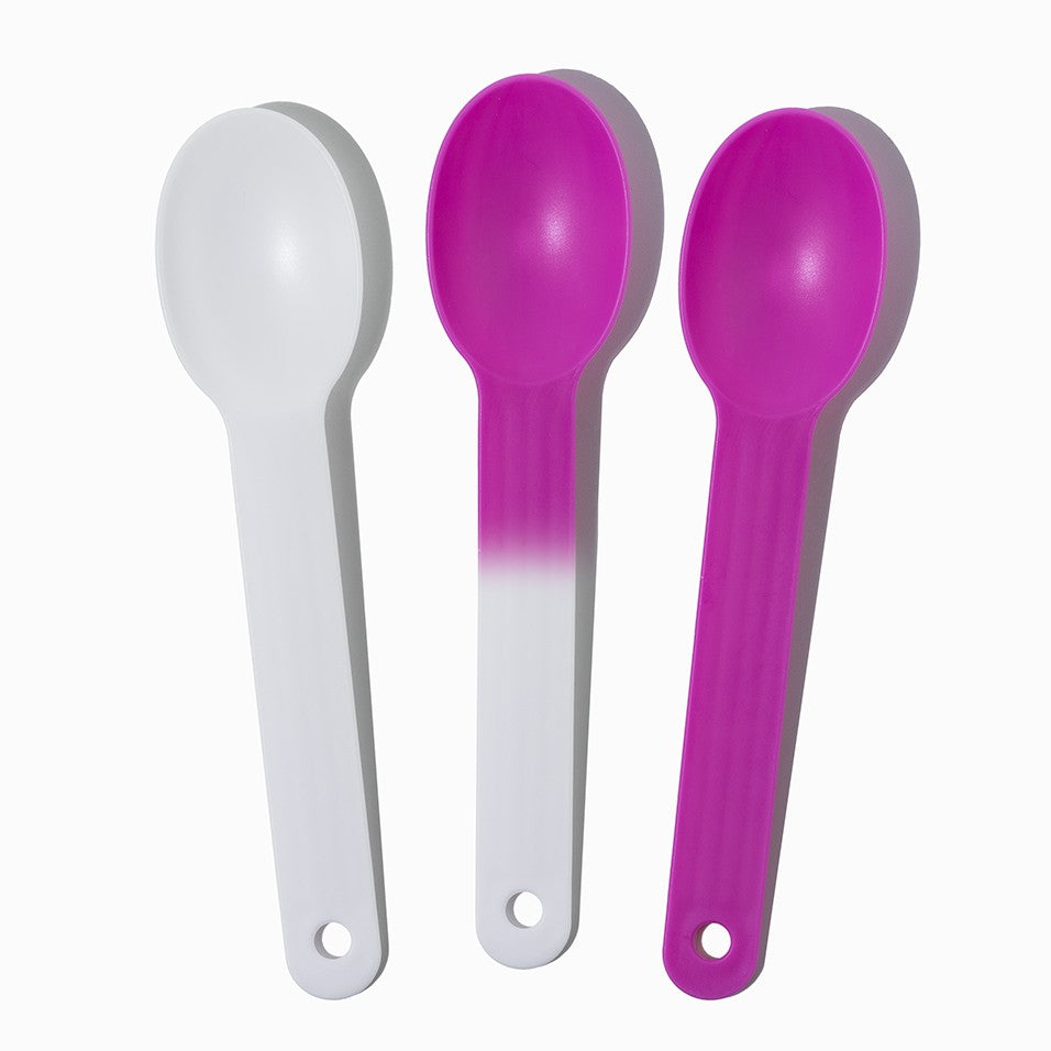 Close-up of white tasting spoons stacked and ready to serve