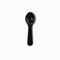 Close-up of black tasting spoons stacked and ready to serve