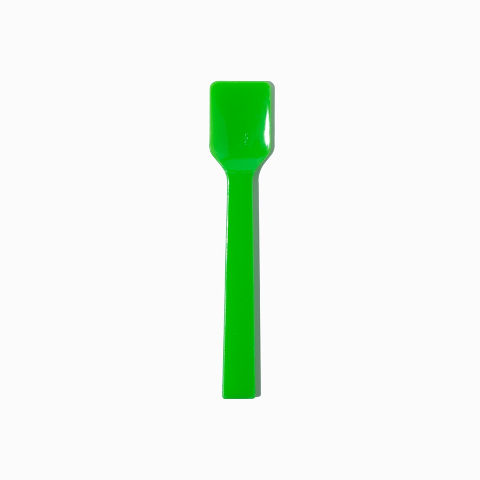 Close-up of green tasting spoons stacked and ready to serve