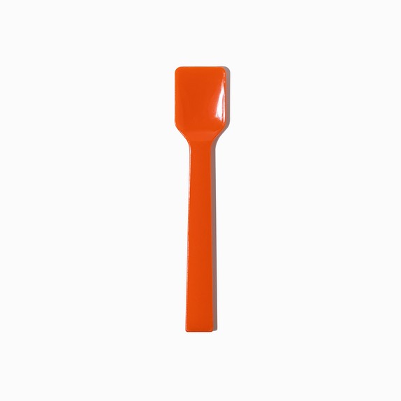 Close-up of orange tasting spoons stacked and ready to serve