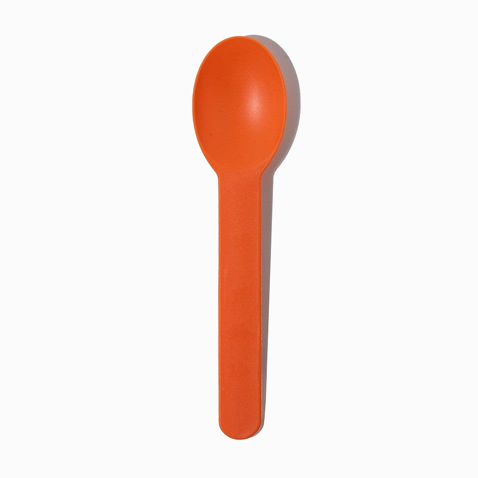 Close-up of orange tasting spoons stacked and ready to serve