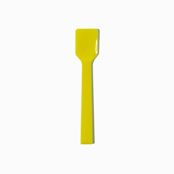 Close-up of yellow tasting spoons stacked and ready to serve