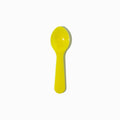 Close-up of yellow tasting spoons stacked and ready to serve