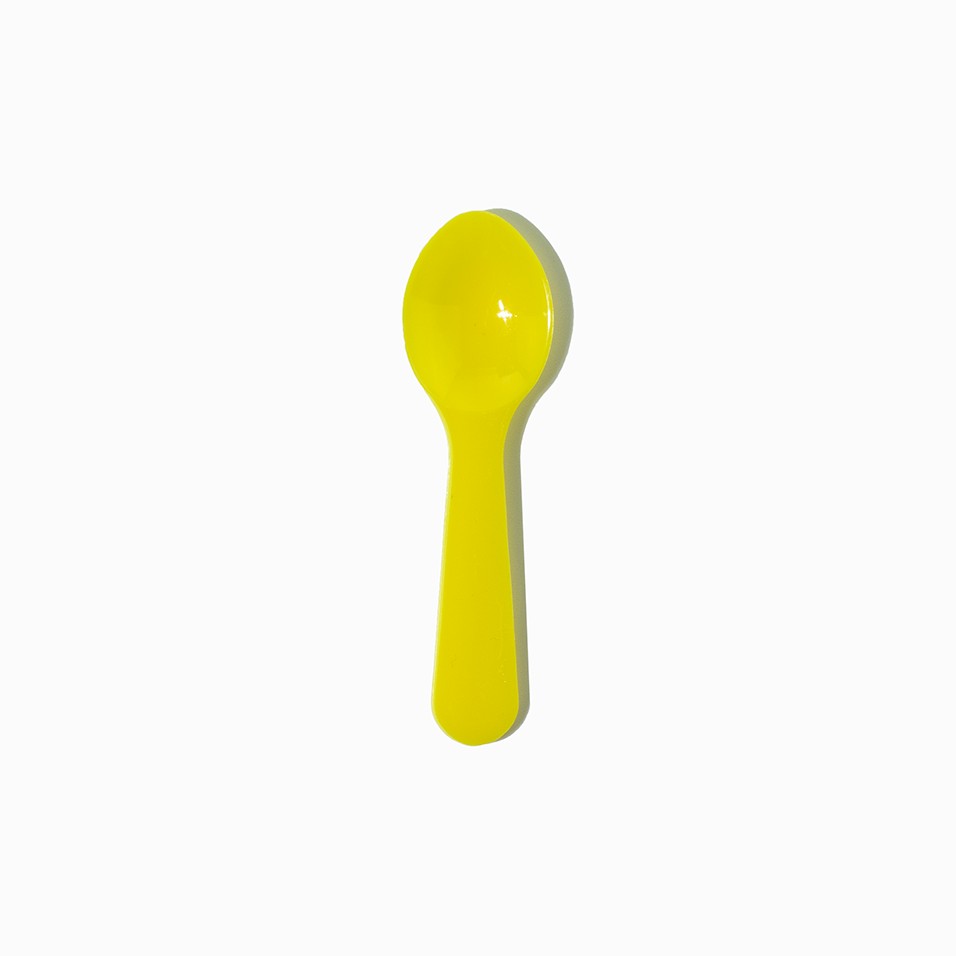 Close-up of yellow tasting spoons stacked and ready to serve